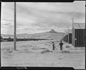 Heart Mountain Relocation Center, Heart Mountain, Wyoming. Looking west on F street, main thoroughfare of this relocation center, with its namesake Heart Mountain looming in the background. By Parker, Tom, Photographer (NARA record: 4682167) (U.S. National Archives and Records Administration) [Public domain], via Wikimedia Commons.