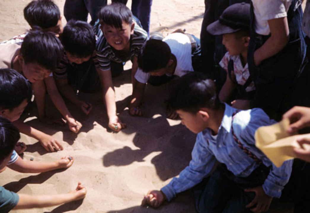 A group of young boys playing marbles in the sand at Amache. Photo courtesy the McClelland Collection held by the Amache Museum, Granada, Colorado.